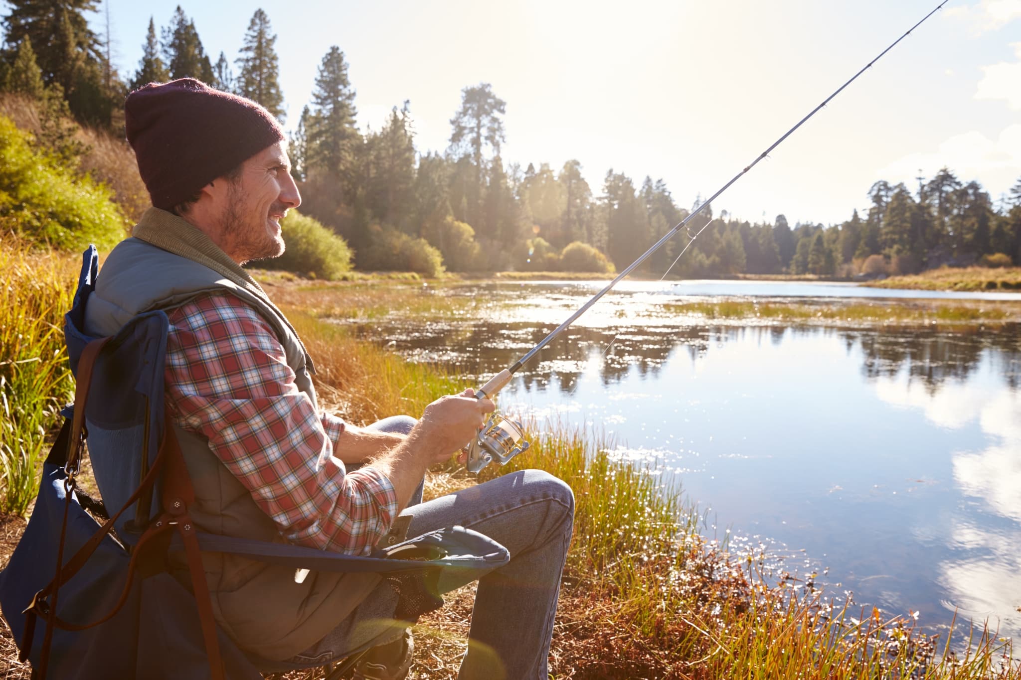 man relaxing and fishing by lakeside california PW74H6C